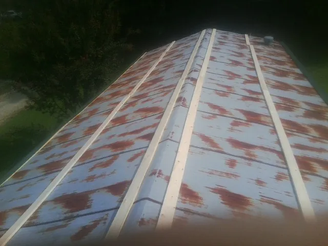 Rusted metal roof panels with new wood purlins before replacement — Storm Damage Roof Repair in Mayesville by Roofing Brothers