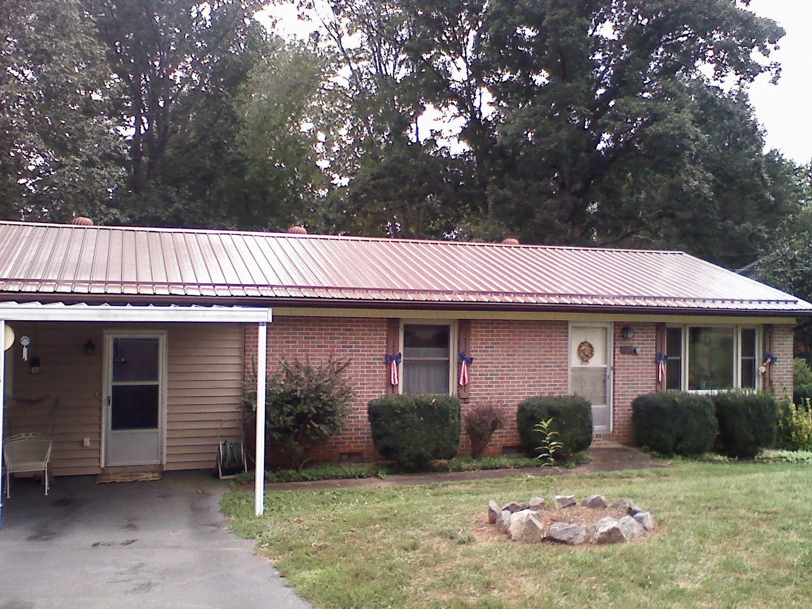 Bronze metal roof and carport on a brick ranch home — Roof Repair work by our crew in Mayesville